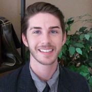 Smiling young man with short dark hair and facial hair